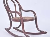 a wooden rocking chair with a wicker seat on a white background