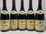 six bouteilles de vin rouge sont alignées sur un comptoir