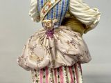 a figurine of a woman in a dress and hat