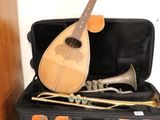 a guitar and a trumpet in a suitcase on top of a stack of suitcases
