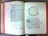 an open book with a ring on it sitting on a table