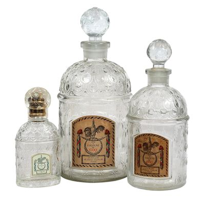 trois bouteilles en verre transparent munies d'un bouchon en liège, disposées les unes à côté des autres
