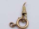 a close up of a gold plated metal hook with a hook