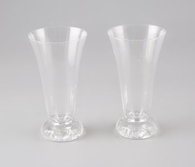 une paire de vases en verre transparent posés sur une table blanche