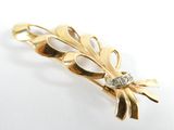 an image of a close up of a gold brooch with a diamond
