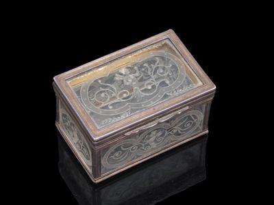 une vieille boîte en argent ornée d'un motif sur fond noir