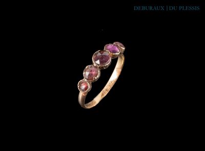 un gros plan d'une bague en or sertie de pierres roses sur fond noir