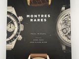 un livre sur lequel sont posées plusieurs montres, posé sur une table