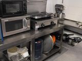 a kitchen with a stove, microwave, and other appliances in it