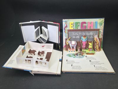un livre ouvert avec une découpe représentant une maison et l'image d'un cheval