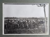 photograph of a large group of people on horses standing in a field