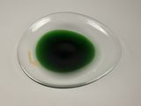 a close up of a green liquid in a glass bowl