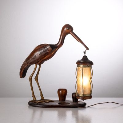 une image représentant une lampe sur laquelle est posé un oiseau