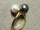 a black and white pearl ring with a gold band