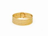 a close up of a gold bracelet on a white background