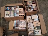 Plusieurs boîtes de DVD sont empilées les unes sur les autres par terre.