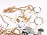 a lot of gold and silver jewelry on a white surface
