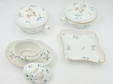 four pieces of china on display on a white table