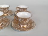 four cups and saucers sitting on a white table