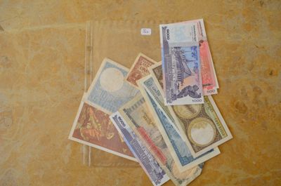 une liasse de billets posée par terre à côté d'une paire de ciseaux