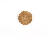 a close up of a gold coin on a white surface