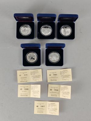 un lot de six pièces d'argent présentées dans des boîtes munies d'étiquettes