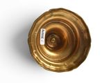 a gold vase with a label on it on a white surface
