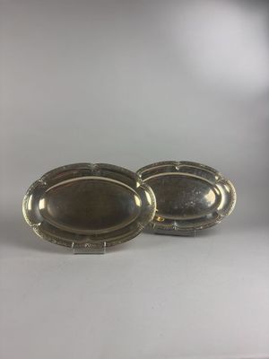 two silver oval trays with handles on a white surface
