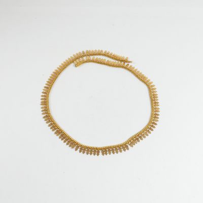 un collier en or sur fond blanc
