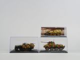 trois modèles différents de véhicules militaires exposés dans une vitrine