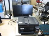 a printer sitting on top of a desk next to a computer monitor