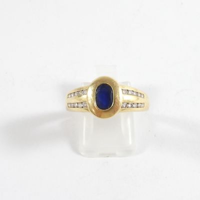 une image d'une bague en or avec une pierre bleue et des diamants