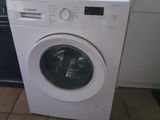a white washing machine sitting in a kitchen next to a dishwasher