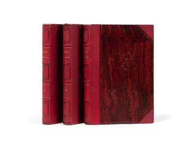 trois livres rouges superposés sur une surface blanche