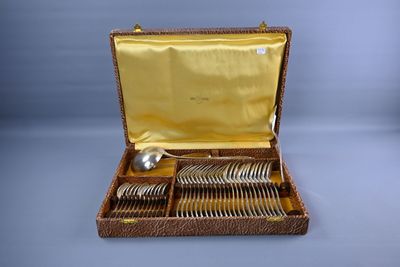 une mallette marron contenant de l'argenterie, posée sur une table
