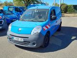 une petite camionnette bleue garée sur un parking