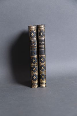 two books are sitting on a gray surface with a gray background