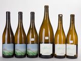 six bottles of wine are lined up in a row on a table