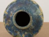 a blue and yellow vase sitting on a table