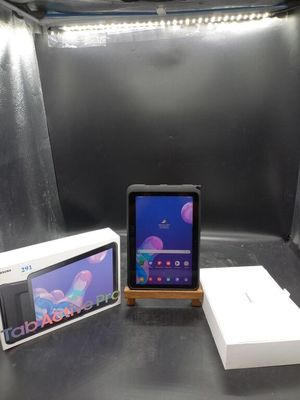 une tablette posée sur une table, à côté d'une boîte