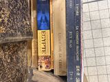 a stack of books sitting on top of an old suitcase