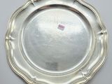 a silver plate on a white table with a pink sticker on it