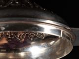 a silver plate with a lid on a black background