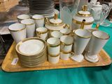 de nombreuses tasses et soucoupes posées sur un plateau, lui-même posé sur une table