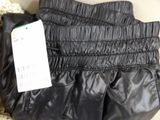 a black purse with a tag on it sitting on the floor