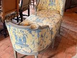 a yellow and blue couch sitting on a brick floor in a room