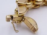 a gold bracelet with a chain that has a bird on it