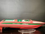 a red and green speed boat on a black surface
