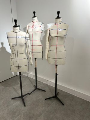 three mannequins are lined up on a stand in a room