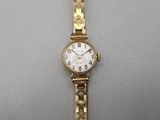 an image of a woman ' s wrist watch sitting on a white surface